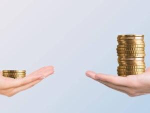 man's hand and woman's hand holding unequal amount of money