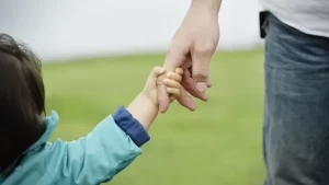 small child holding father's hand